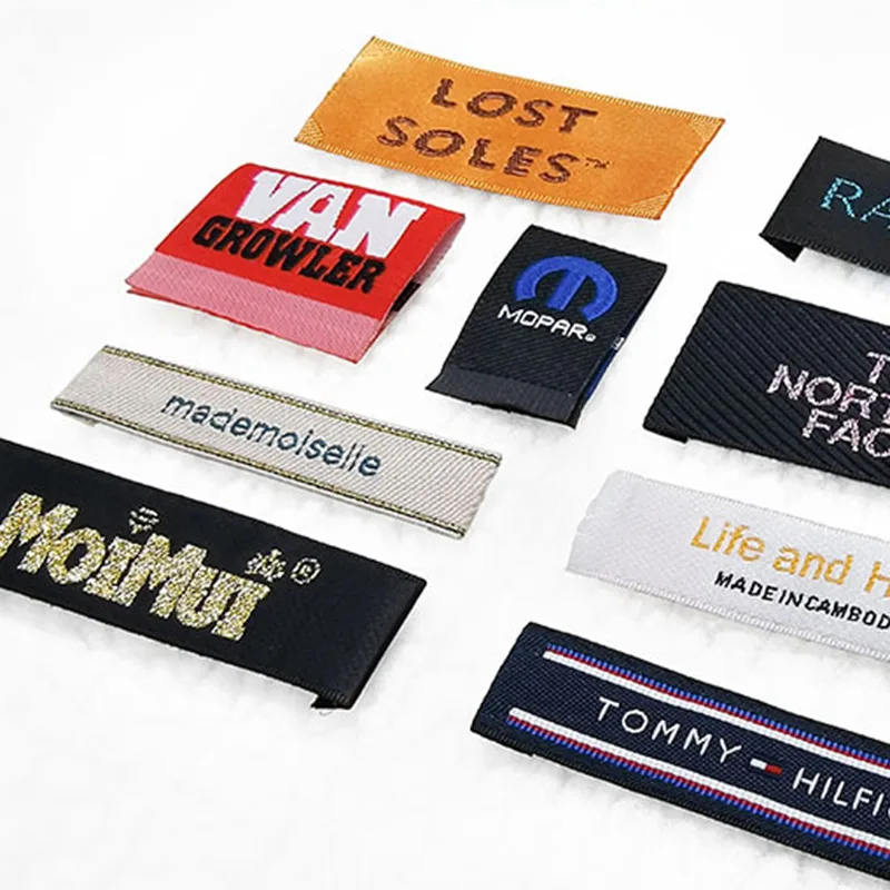 Assorted branded clothing labels on white background.