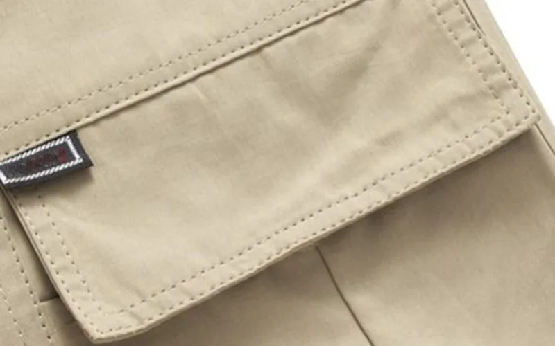 Close-up of beige pants pocket with label.