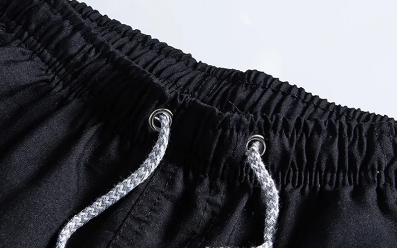 Close-up of black drawstring sweatpants waistband.