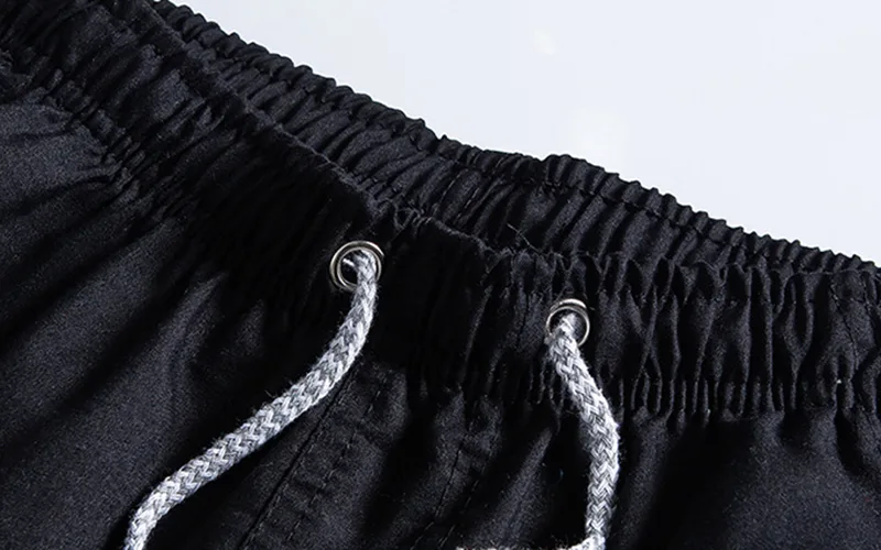 beach volleyball shorts 6 jpg Close-up of black drawstring sweatpants waistband.