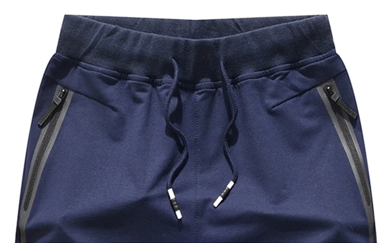 Blue athletic shorts with drawstring and zip pockets.