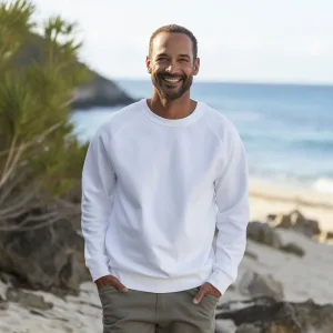Man smiling on beach in casual attire.