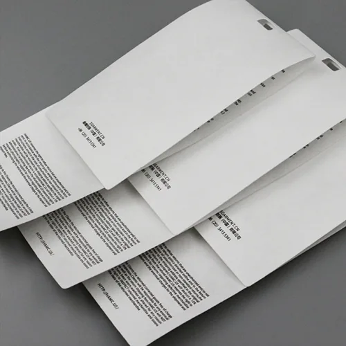 custom tyvek labels jpg Stack of printed, perforated white papers.