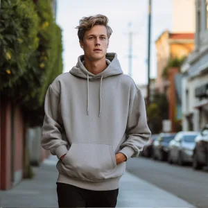 Man in gray hoodie walking on city street.