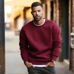 Man in burgundy sweater posing outdoors.