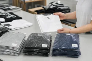 custom t-shirt packaging setup with folded shirts, labels, and polybags