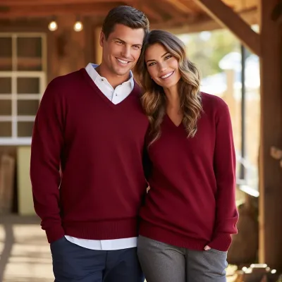 Couple wearing matching red sweaters smiling.